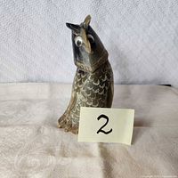 Front view of tusk carved owl figurine with scale pattern and eyes