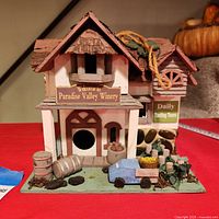 Front view showing winery sign, bird entry hole, decorative barrels and cart