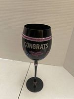 Front view showing "CONGRATS" text, rhinestone band, floral accents