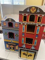 Front view closed playhouse showing fire station and police facade