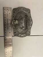 Front of Cazadores belt buckle beside ruler showing size