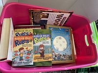 Pink Mega Bloks tub open showing assorted children’s books inside