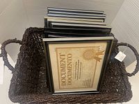 Stacked gunmetal/gray photo frames inside woven basket