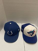 Front view of both caps showing team logos