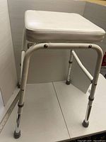 Full view of stool showing legs, height adjustment mechanism and seat