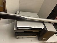 Stacked electronics with silver cylindrical speaker across top