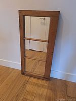 Full view of pine window frame mirror leaning against wall