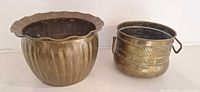 Two brass planters side by side, showing overall design and size difference