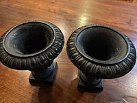 Top view of both cast iron urns showing fluted rims and interior