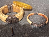 three bracelets and pin laid out