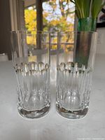 Two of the six cut-crystal highball glasses standing on countertop