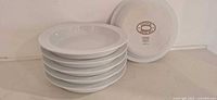 Stack of six white Dansk bowls with one inverted showing stamp