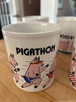 Front view of Pigathon mug with running pig graphic