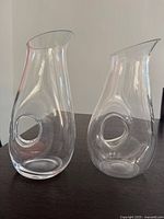 Two clear glass carafes side by side on table