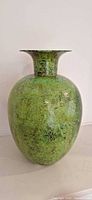 Full front view of green mottled metal vase