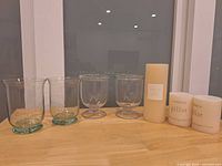 Four hurricane holders and three candles on tabletop