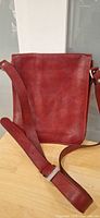 Front view of red leather shoulder purse with strap