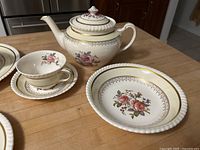 Teapot with lid, cup, saucer and bowl showing pattern and rope edge