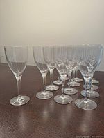 Side view of 13 Orrefors crystal white wine glasses on table