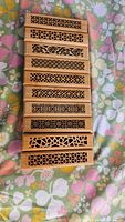 Stack of carved wooden incense holders showing various lattice designs