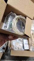 Box containing coiled copper wire micro LED string with clear battery pack
