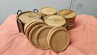 Cluster of round wooden coasters displayed in front of round holder