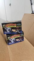 Front view of two boxed reptile heating lamps