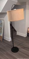 Full view of floor lamp showing base, pole, shade
