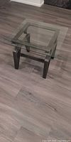 Square tempered glass side table with cast aluminum base shown assembled
