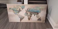 Front view of canvas world map art leaning against wall