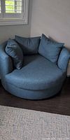 Front view of round teal lounge chair with three cushions
