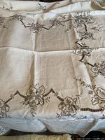 Full view of embroidered linen tablecloth spread out