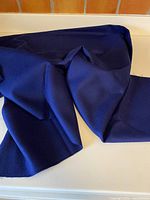 Folded length of navy wool fabric displayed on counter