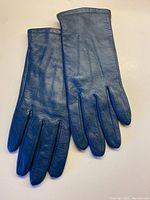 Full view of both teal leather gloves