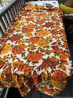 Full view of bed cover laid flat showing ruffled perimeter and overall floral pattern