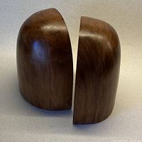 Both half-oval solid wood bookends angled apart showing grain and shape