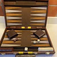 Open backgammon case showing board, pieces, dice, cups and doubling cube