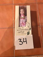 Front view of boxed porcelain doll showing size and packaging