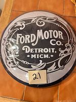 Front view of sealed round Ford Motor Co. tin sign
