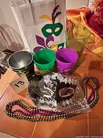 Overall lot showing gift bag, cups, pails, mask and bead strands