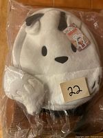 Front view of plush Twig backpack in plastic