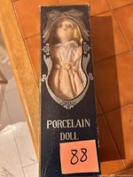 Front of boxed porcelain doll showing window and label