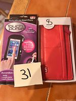 Front view of boxed Touch Purse next to red Stella & Fritz wallet