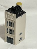 Front angled view showing facade, roof detail, yellow cap, printed KLM and BOLS logos, number 75