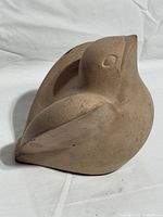 Front angled view of tan stylized bird sculpture