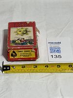 Closed tarot deck box beside tape measure for scale, showing wear