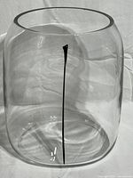 Front view of large clear glass vase with vertical black line