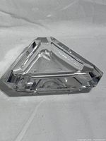 Top angled view of triangular clear cut crystal ashtray showing faceted edges