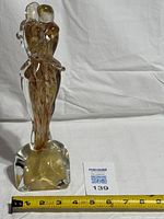 Front view of Murano embracing lovers glass sculpture with ruler for scale