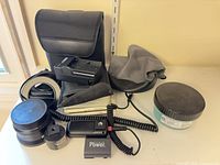 Lens, caps, charger, battery, remote, lens hood, cases, rings grouped on shelf
